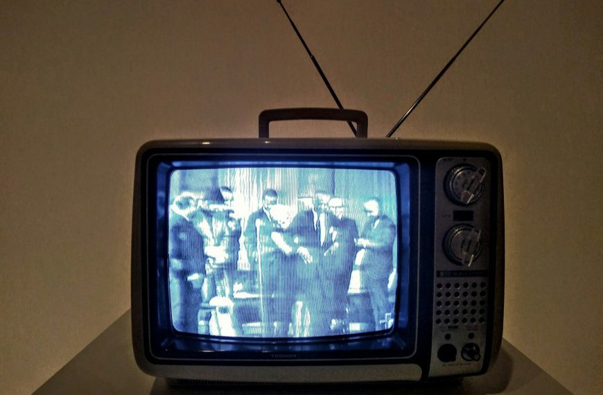 black crt tv turned on on white table