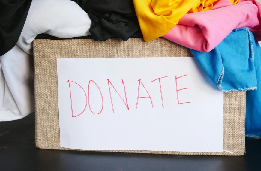 A donation box filled with colorful clothing, symbolizing charity and community support.