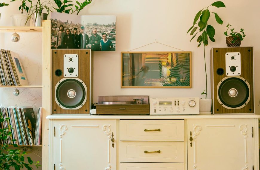 Retro home interior featuring vintage stereo, speakers, and houseplants for cozy atmosphere.