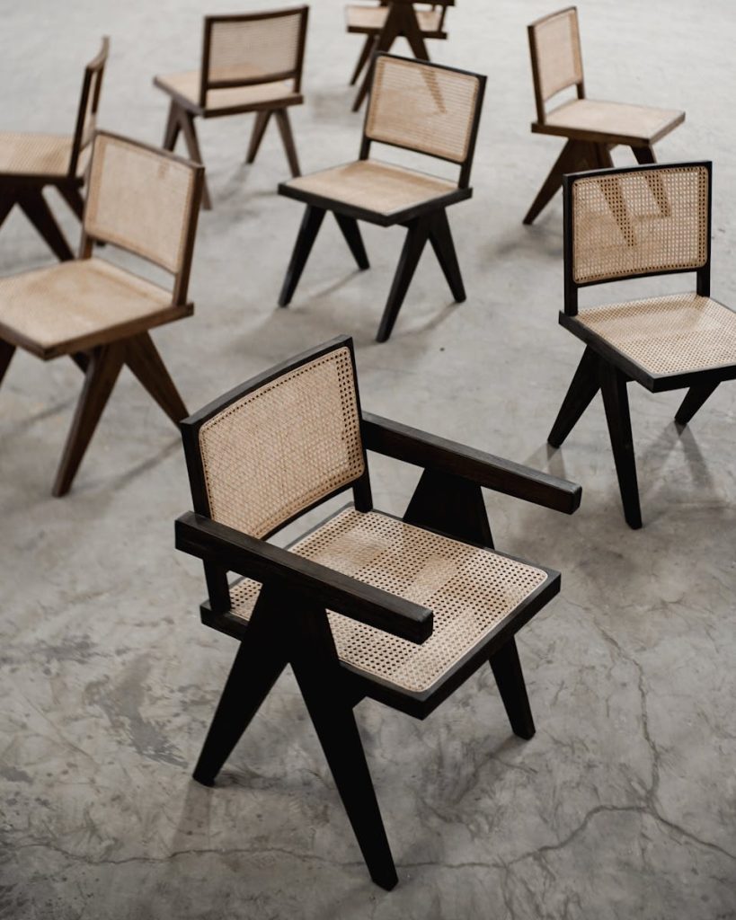 A stylish arrangement of wooden chairs with woven seats on a concrete floor.