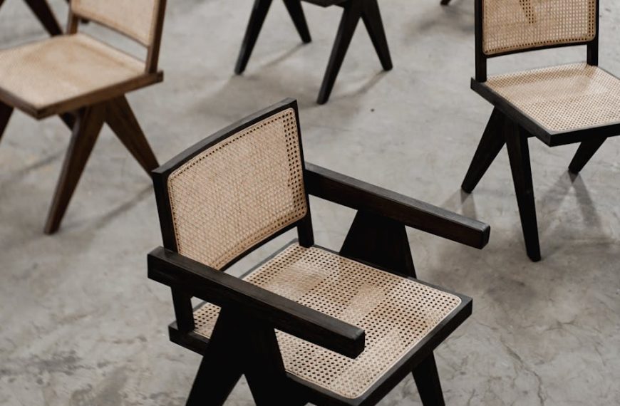 A stylish arrangement of wooden chairs with woven seats on a concrete floor.