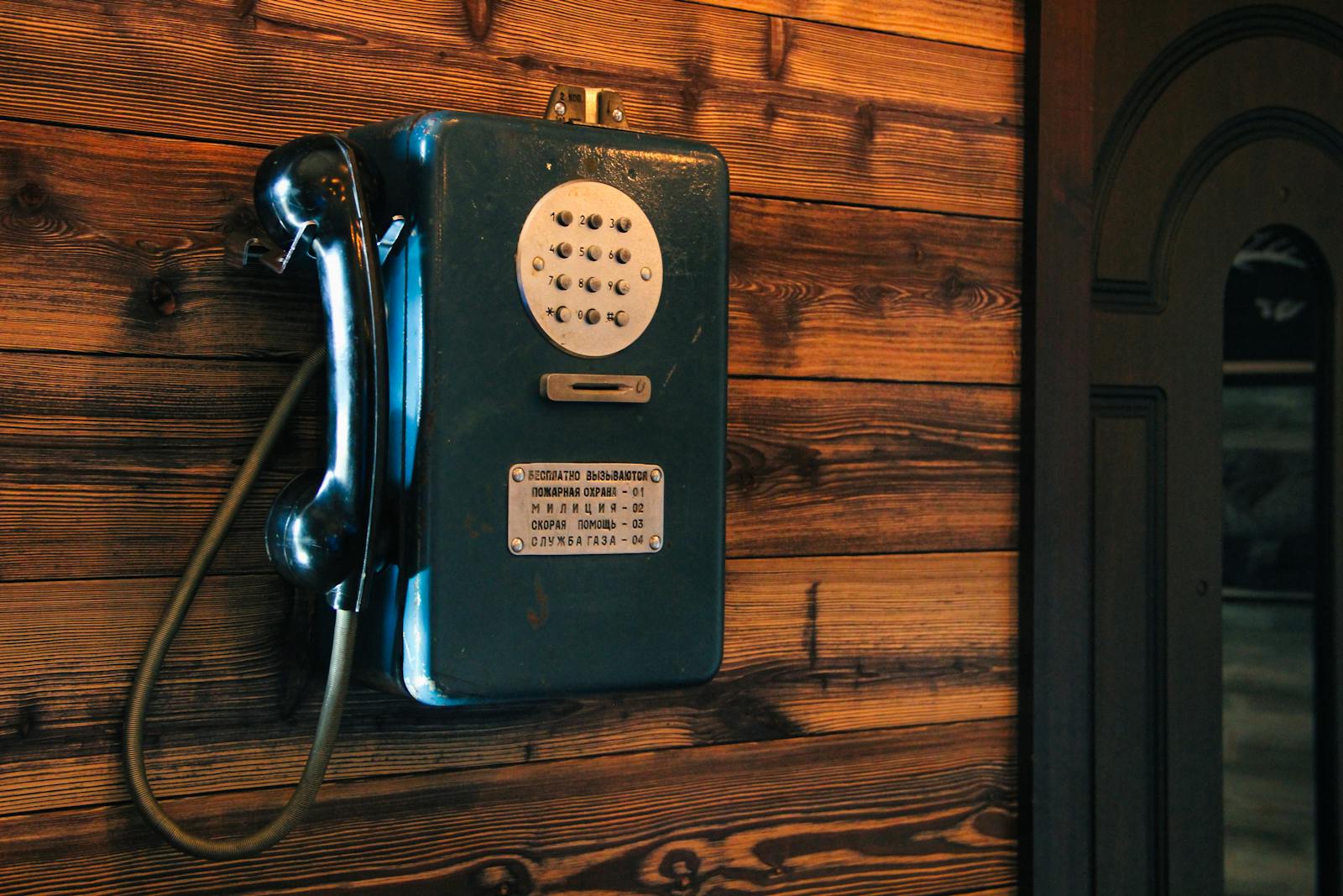 A classic vintage rotary phone mounted on rustic wooden wall, adding a touch of nostalgia and retro charm.