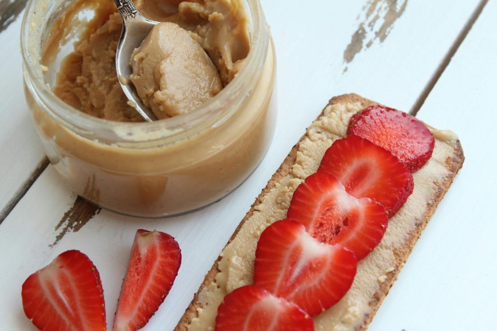 A delicious close-up of peanut butter and fresh strawberries on toast. Perfect for breakfast ideas.
