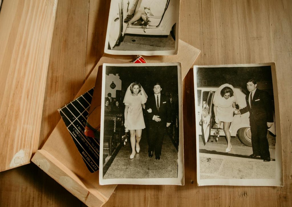 Vintage black and white wedding photos displayed on a wooden table.