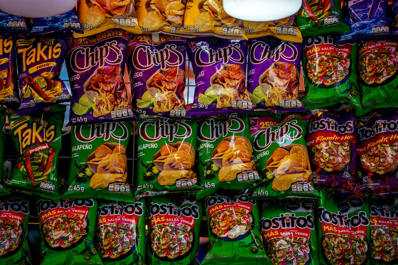 Colorful assortment of snack bags displayed on a shelf, showcasing popular brands and flavors.