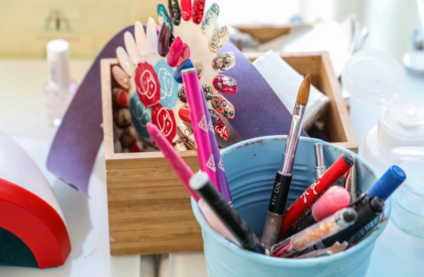 Vibrant desk scene with colorful makeup and nail art tools in containers.