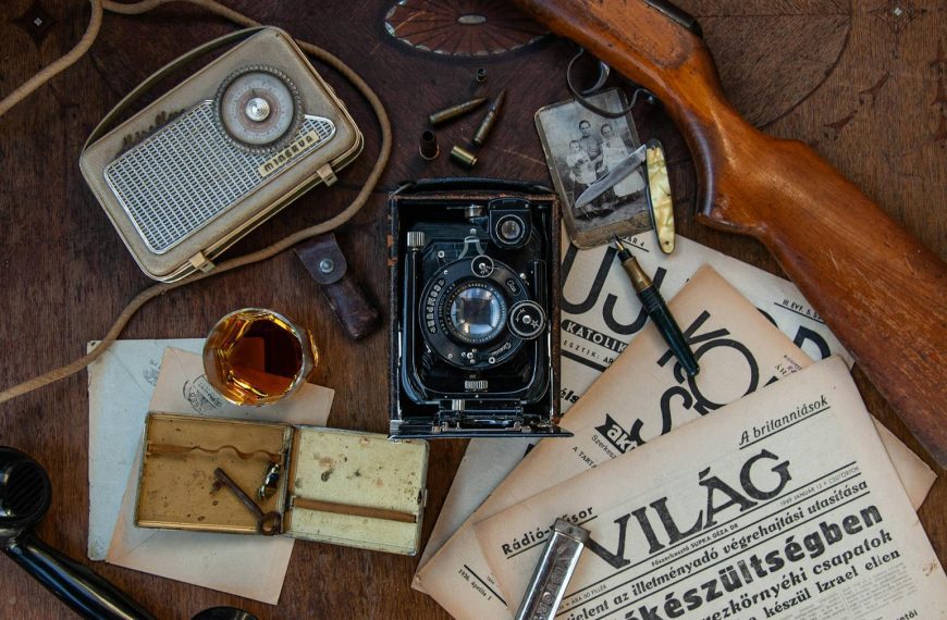 A collection of vintage items including a camera, radio, and newspaper creates an old-fashioned vibe.