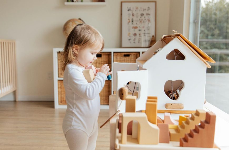 Cute toddler engaging with wooden toys in a bright indoor setting.