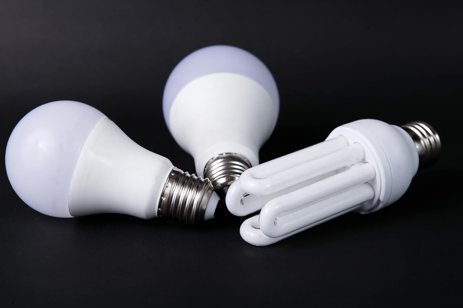 Close-up of energy-efficient LED and CFL light bulbs on black background.