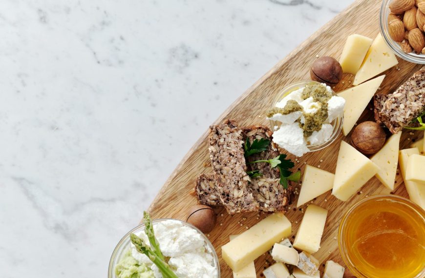 Delicious gourmet cheese platter featuring assorted cheeses, nuts, and honey on a rustic wooden board.