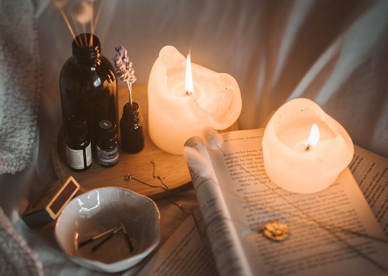 Warm, inviting bedroom setting with candles, books, and soft lighting creating a cozy atmosphere.
