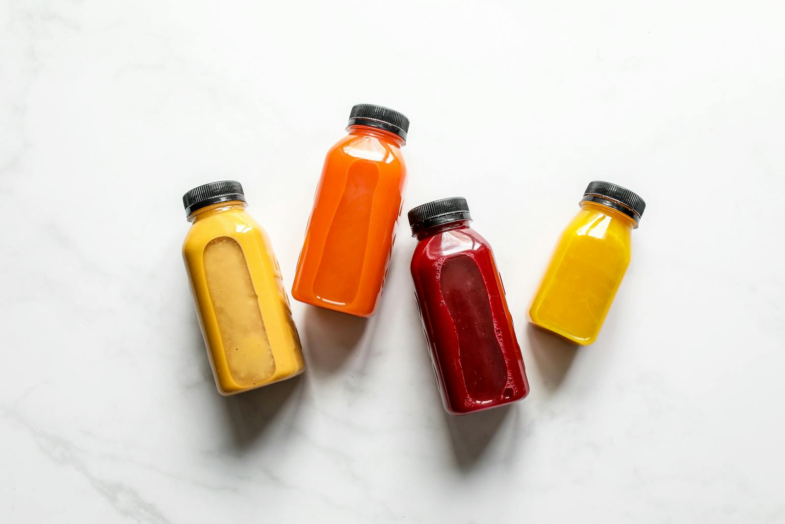 Colorful smoothies in bottles on a white background, ideal for healthy lifestyle concepts.