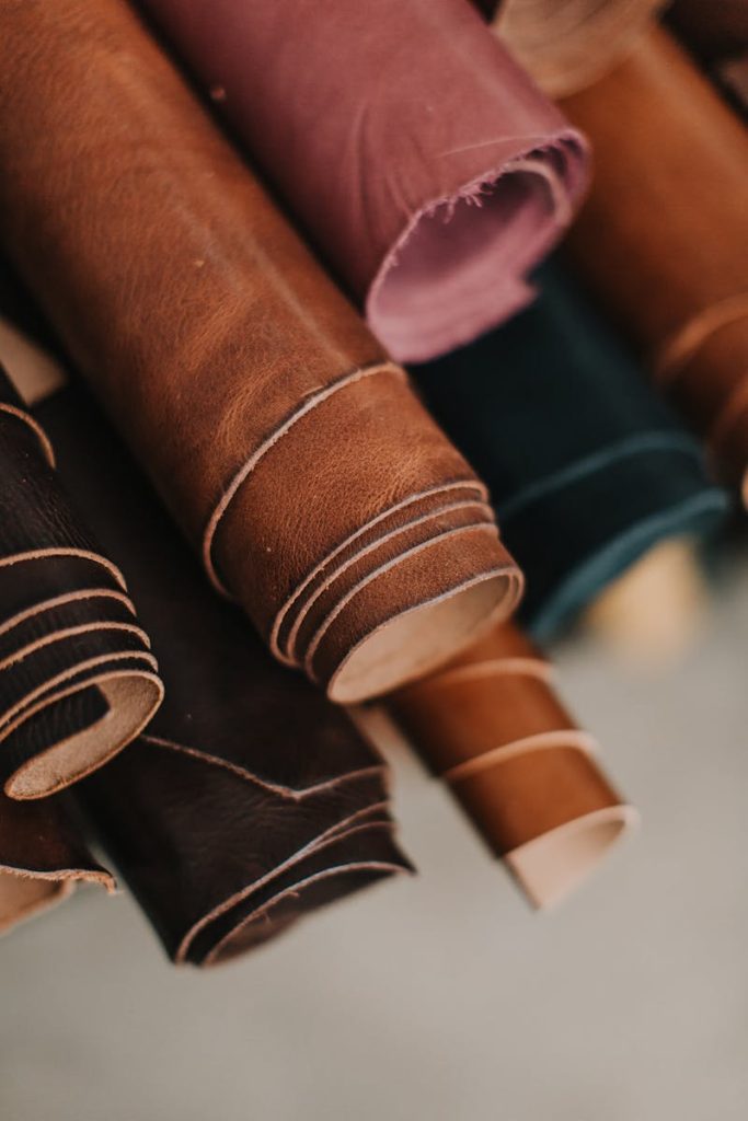 Close-up of assorted multicolored leather rolls in a craftsman workshop setting.