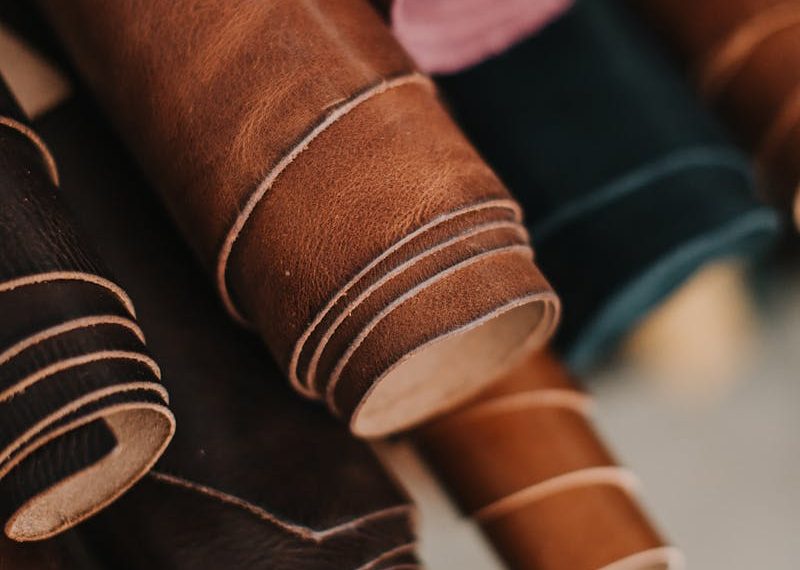 Close-up of assorted multicolored leather rolls in a craftsman workshop setting.