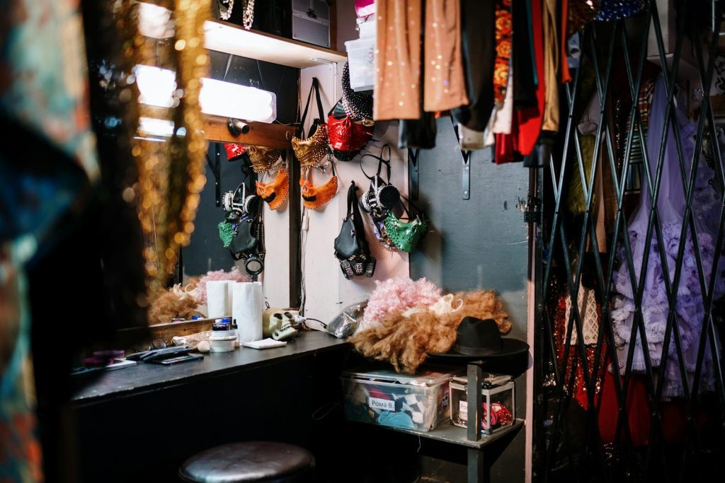 A vibrant dressing room filled with colorful costumes and theatrical accessories.