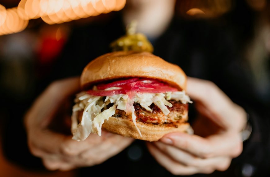 a person holding a sandwich in their hands