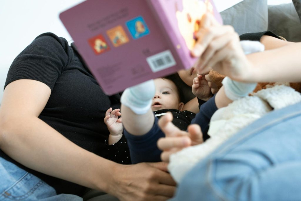 A baby and family reading together, promoting love and education. Cozy indoors setting.