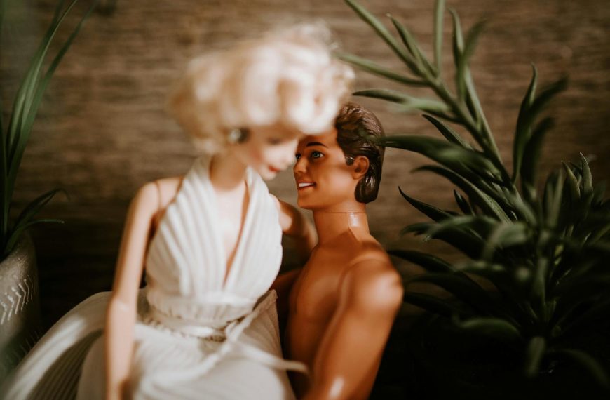 Romantic scene with dolls embracing, surrounded by indoor plants.