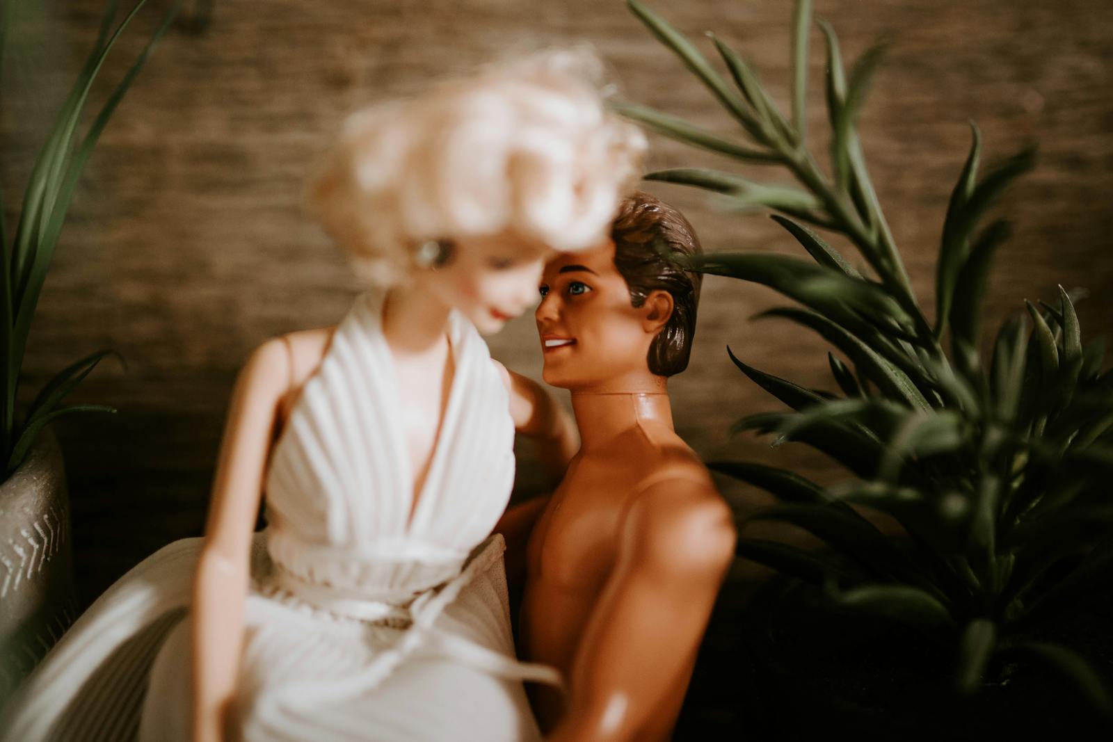 Romantic scene with dolls embracing, surrounded by indoor plants.
