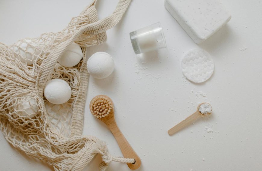 Minimalist flat lay of eco-friendly bath essentials including bath bombs, soap, and a brush.