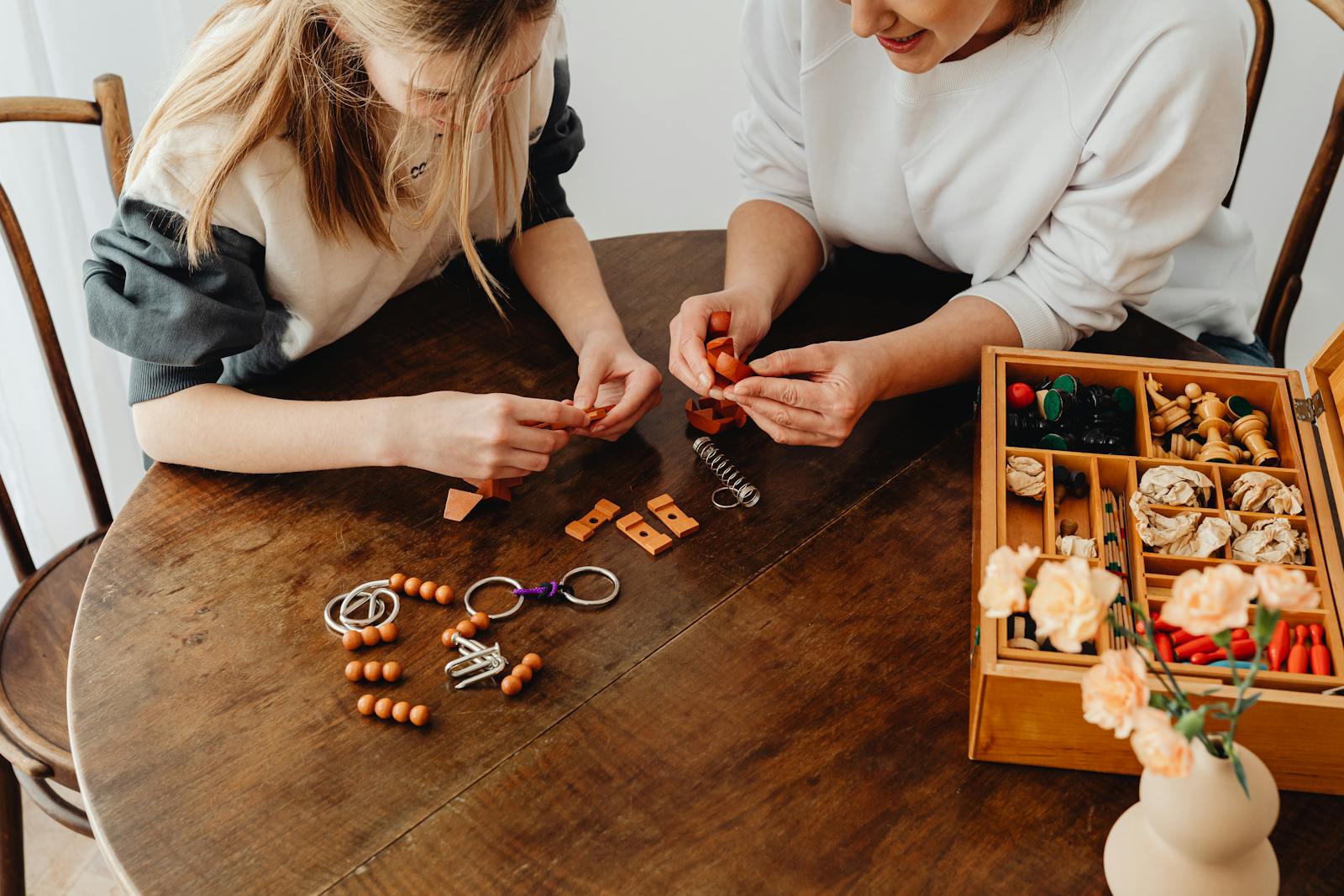 Two women engaging in a creative DIY crafting session on a rustic wooden table.