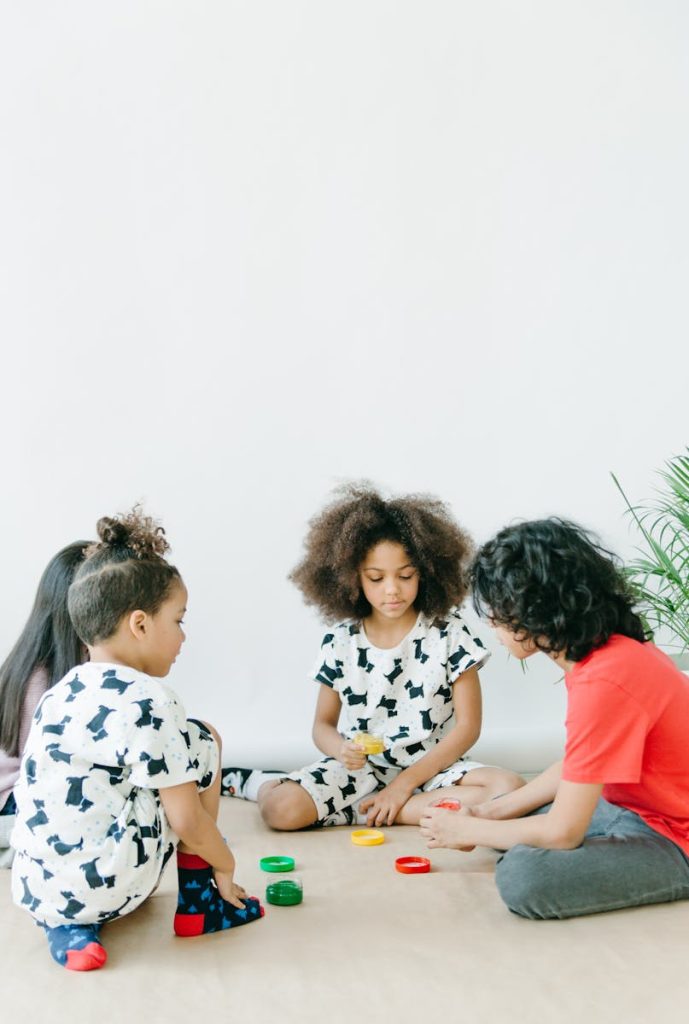 Four children enjoying a creative indoor playtime with paints and crafts in a bright setting.