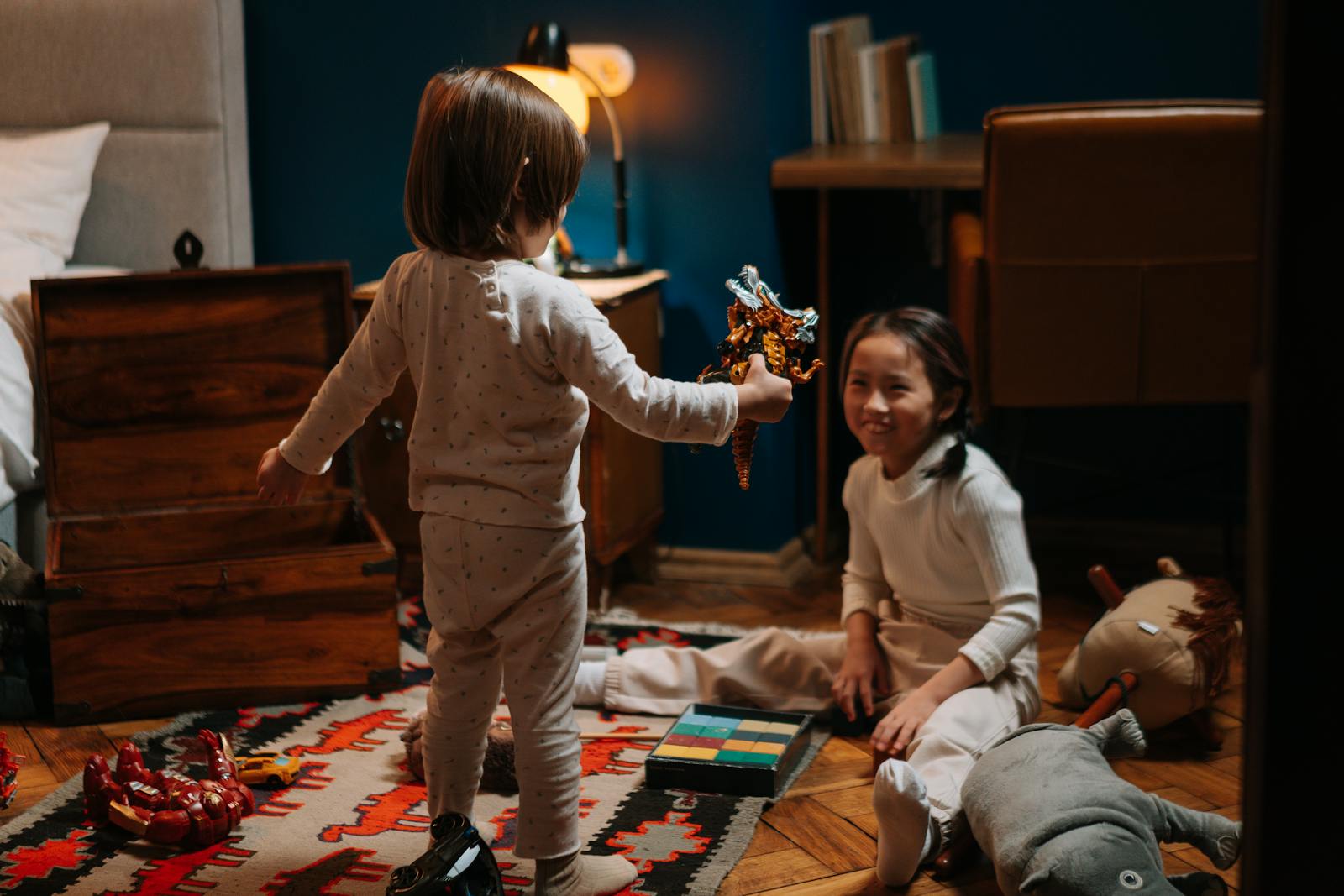 Two siblings having fun with toys in a cozy room, creating joyful memories.
