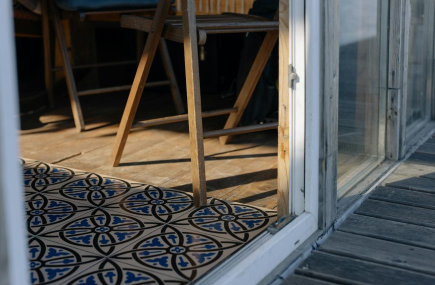Wooden chair by a decorative tiled floor in a sunlit room, creating a warm, rustic atmosphere.