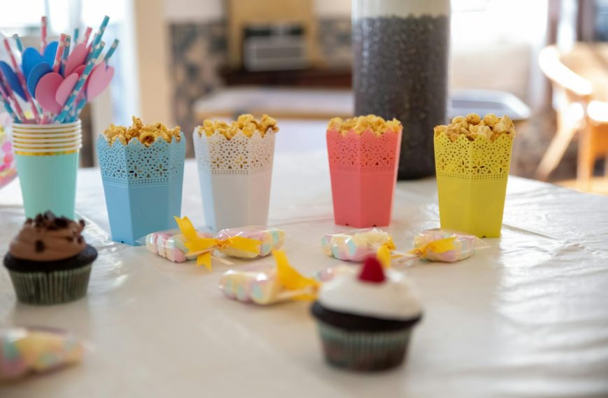 A vibrant table setup with popcorn and cupcakes, ideal for celebrations and parties.