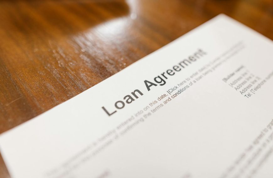 Detailed loan agreement document close-up on a wooden table representing legal and financial concepts.