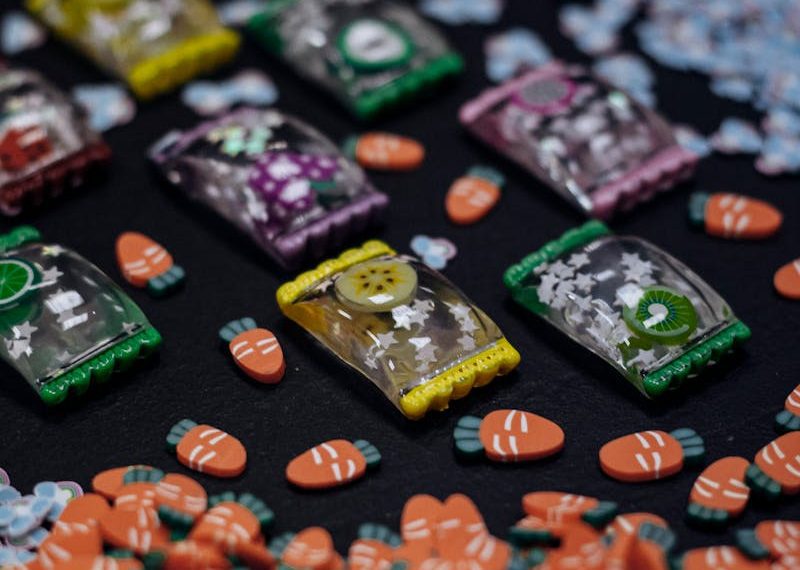 Close-up of colorful candies and packages on a black surface.