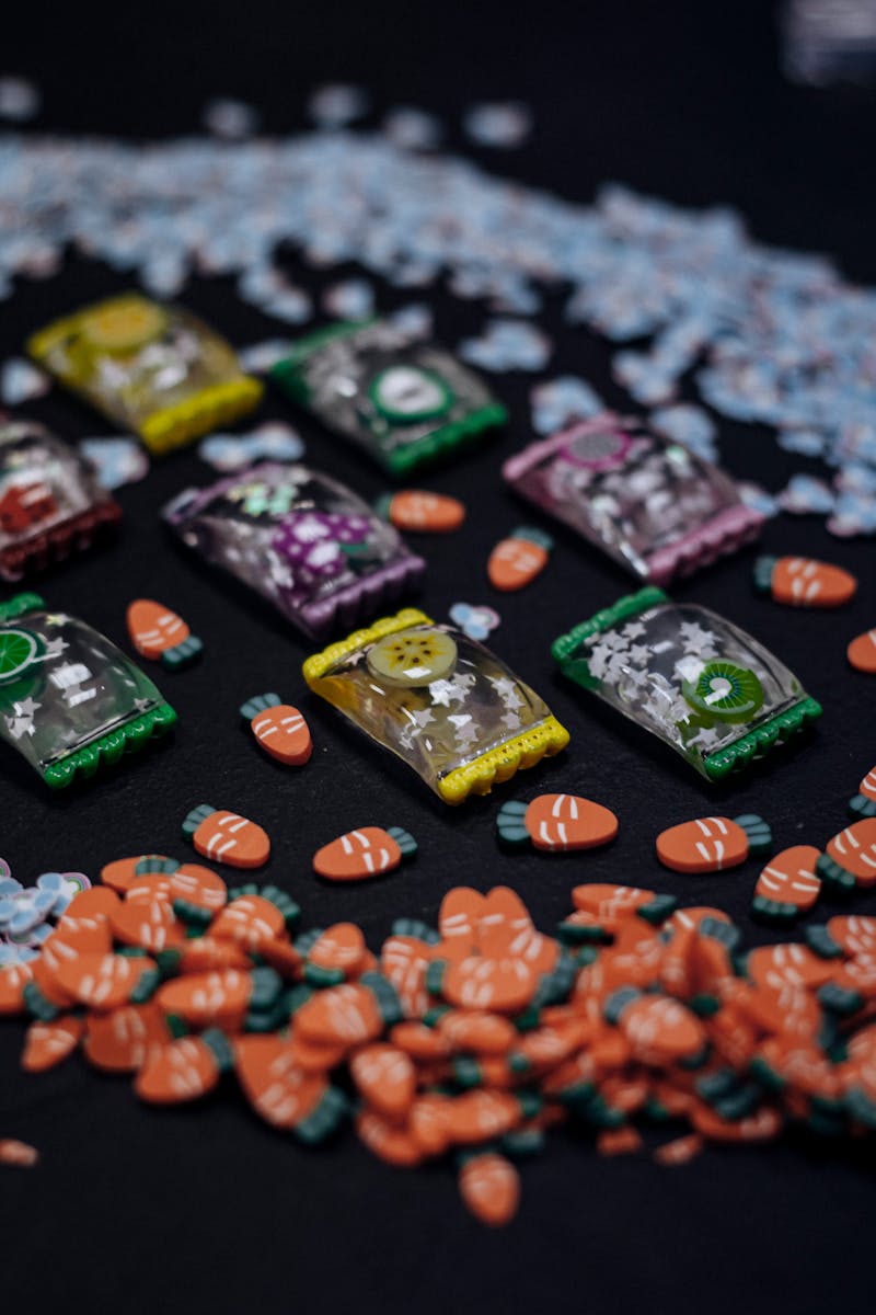 Close-up of colorful candies and packages on a black surface.