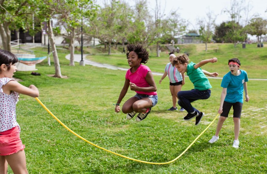 Children enjoying a vibrant day playing jump rope outdoors at summer camp.