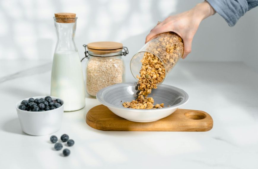 Fresh granola poured into a bowl with milk and blueberries for breakfast.