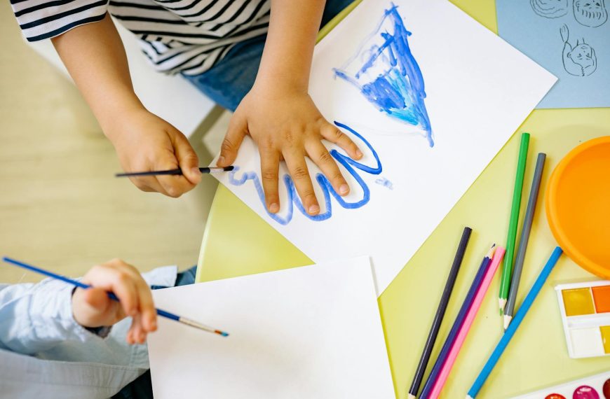 Children painting with watercolors and colored pencils, fostering creativity and learning in a fun environment.