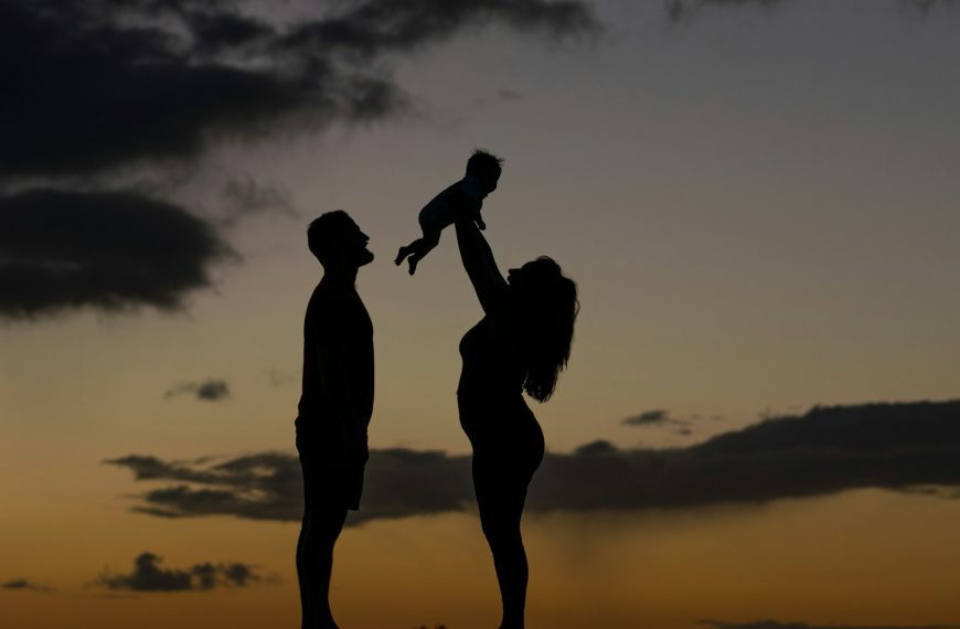 a silhouette of a man and a woman holding a baby