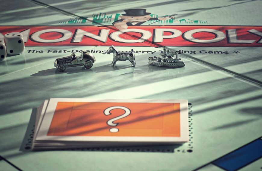 Close-up of Monopoly board game with metal tokens and dice in warm light.