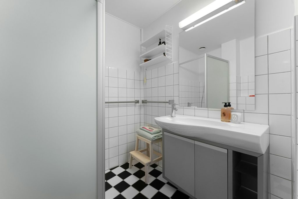 A bathroom with a checkered floor and white walls