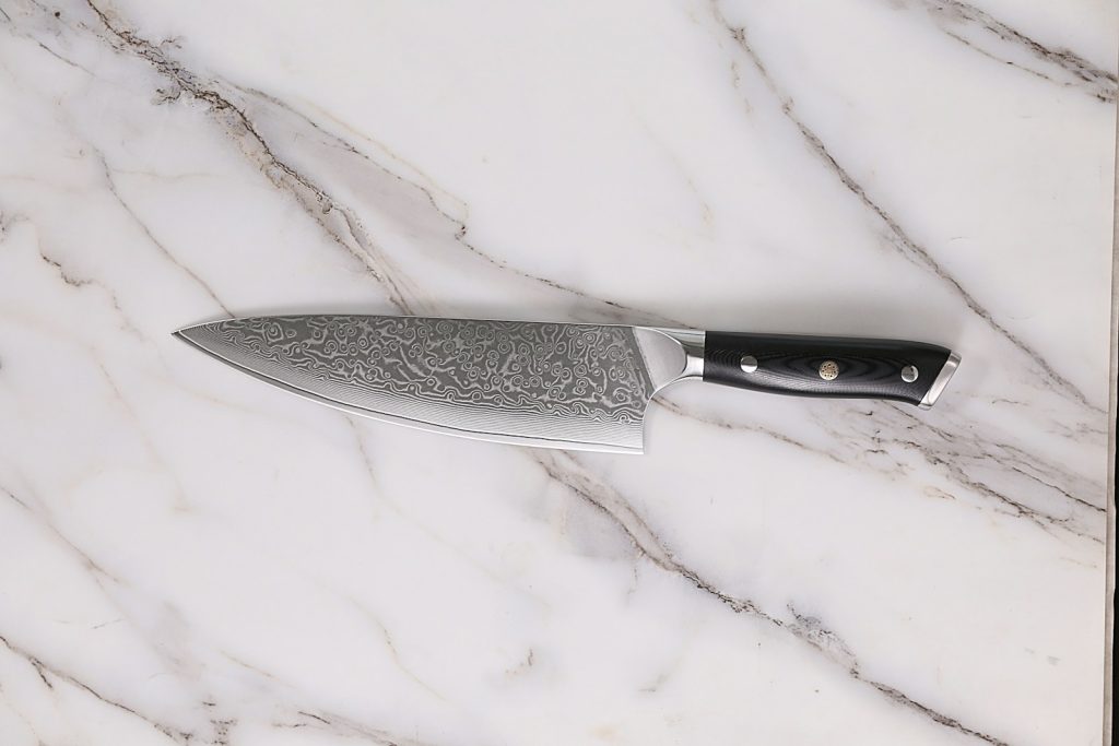 a large knife sitting on top of a marble counter