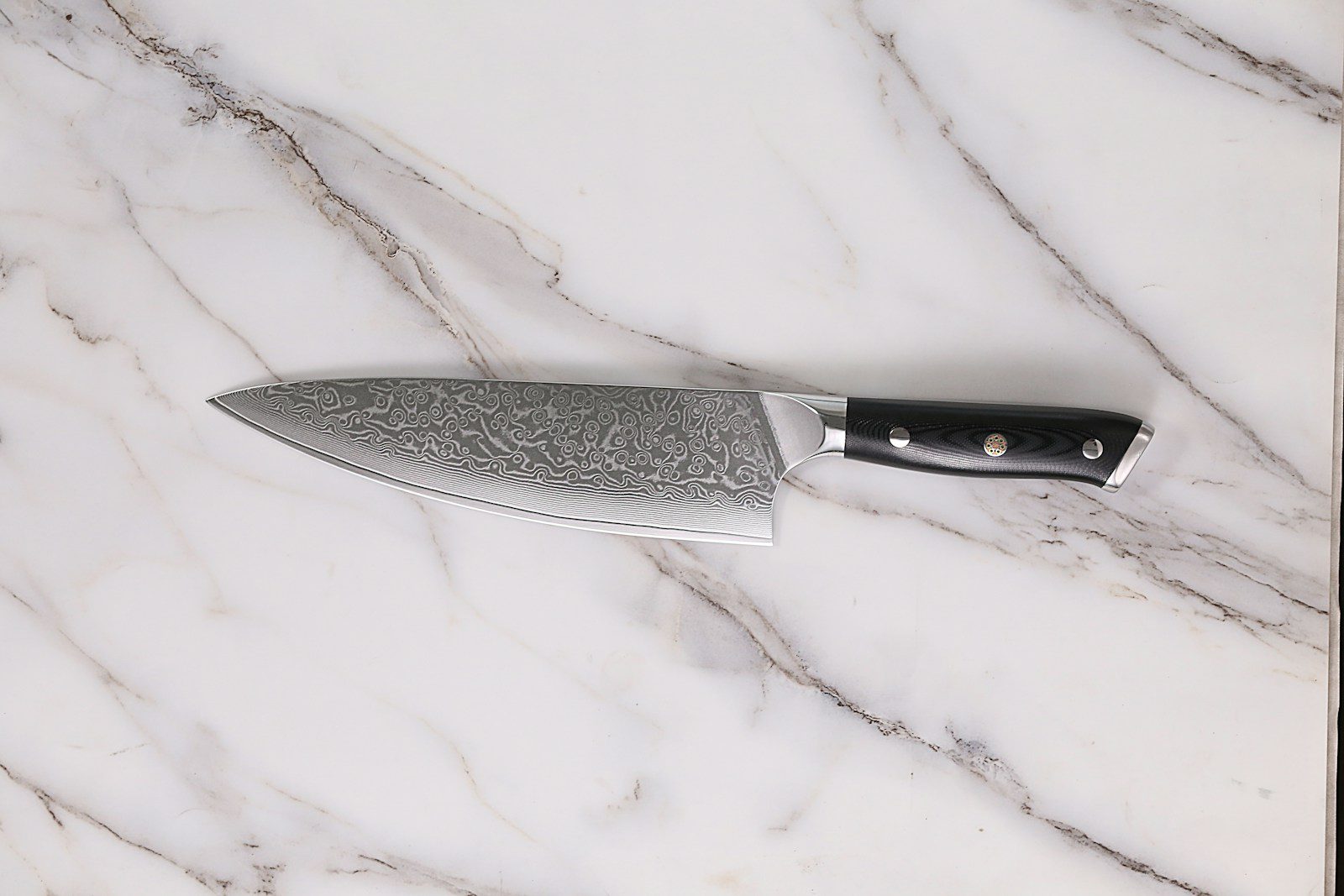 a large knife sitting on top of a marble counter