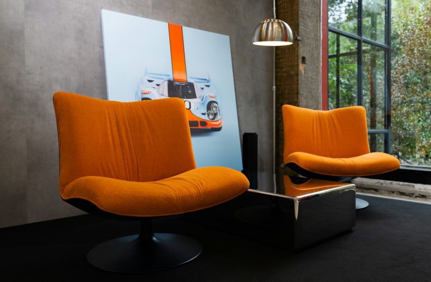 Two orange chairs and a modern coffee table.