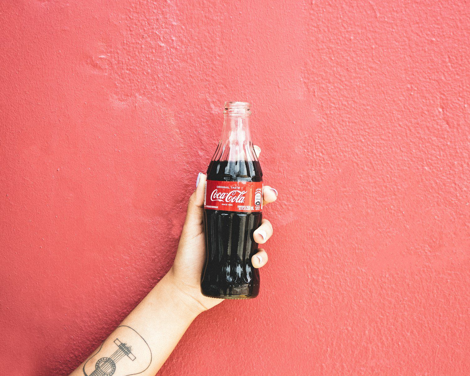 coca cola bottle on persons hand