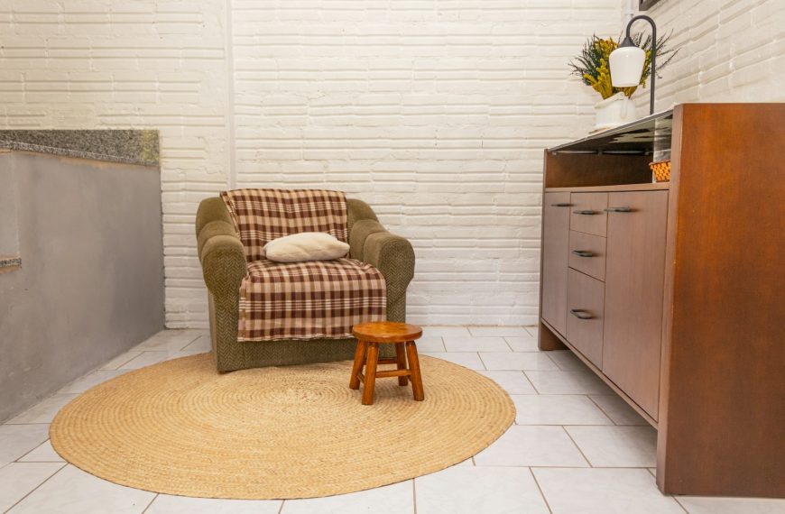 Armchair with blanket and stool on rug