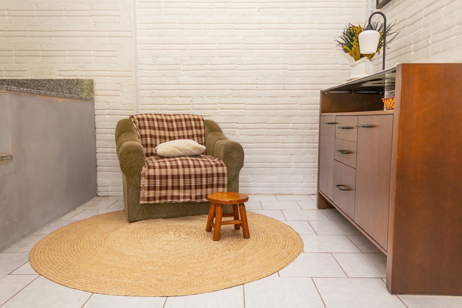 Armchair with blanket and stool on rug