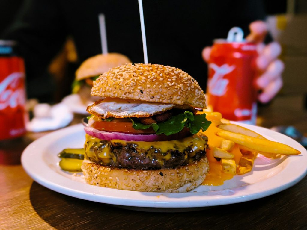 burger with lettuce and tomato on white ceramic plate