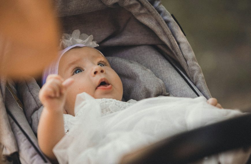 a baby in a stroller looking up at something