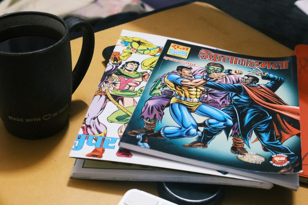 Stack of comic books next to a mug of coffee.