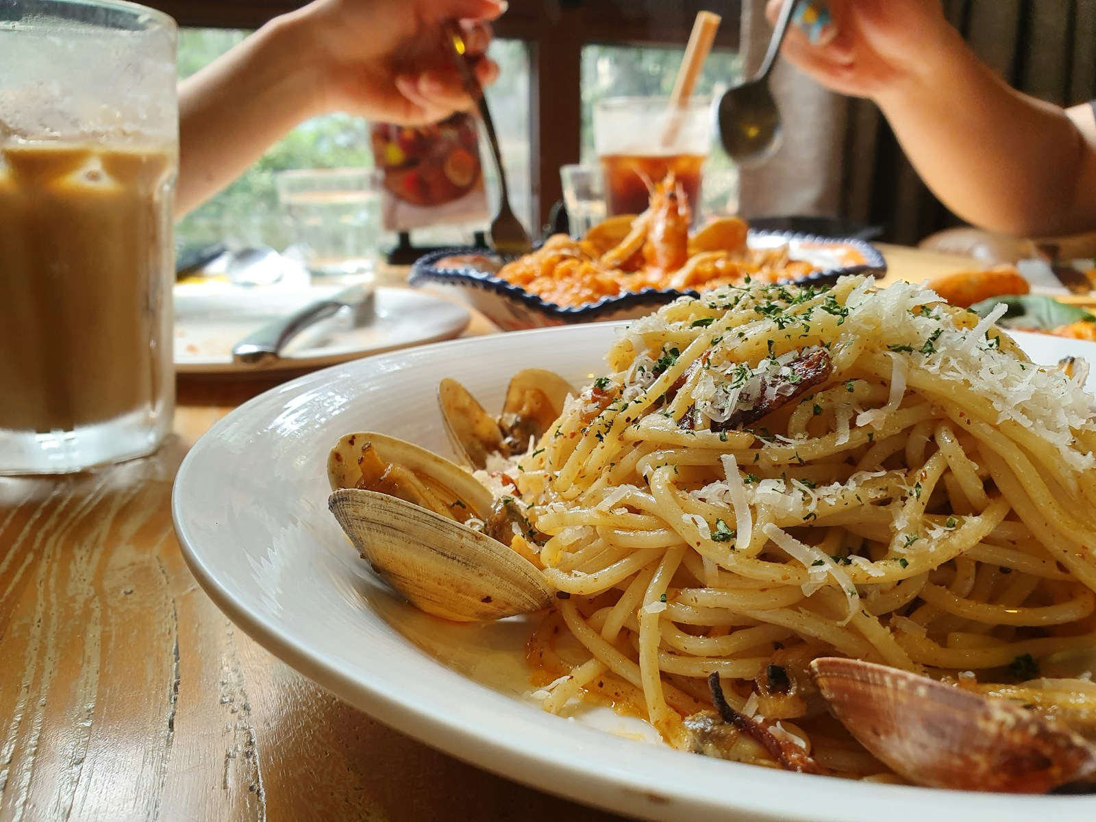 a plate of pasta with clams and sauce on a table