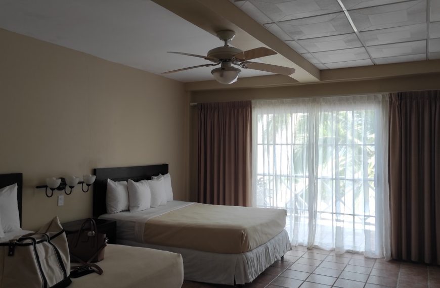 a hotel room with two beds and a ceiling fan