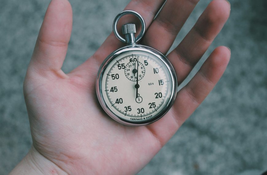 person holding white and silver-colored pocket watch